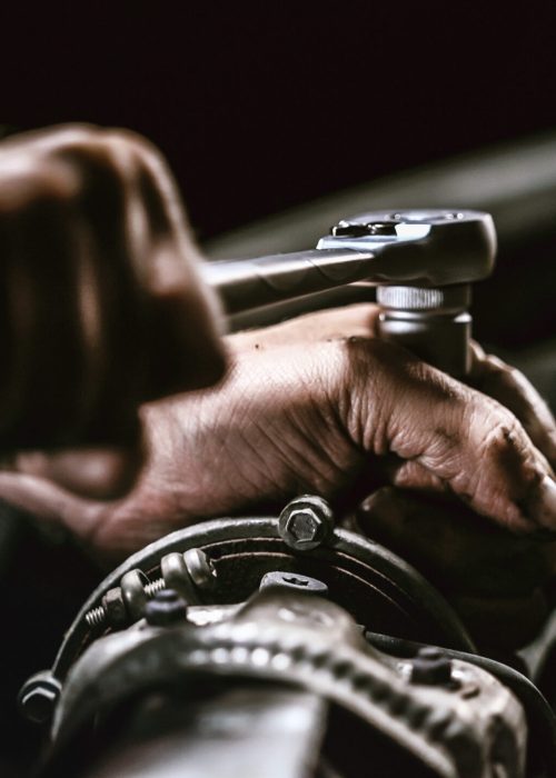Auto mechanic working on car engine in mechanics garage. Repair service. authentic close-up shot