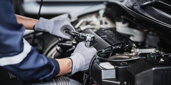 Professional mechanic working on the engine of the car in the garage. Car repair service.