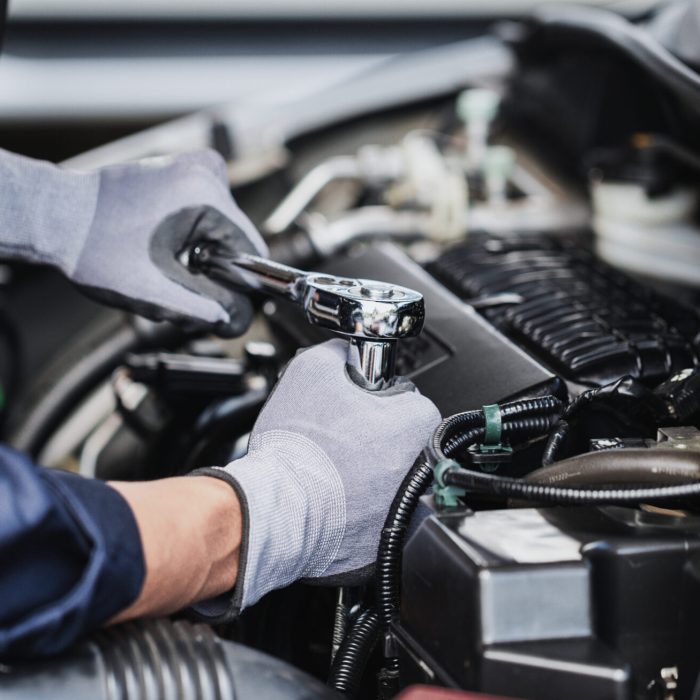 Professional mechanic working on the engine of the car in the garage. Car repair service.